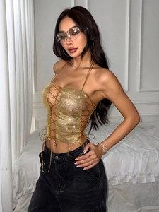 Close-up of golden metallic mesh crop top featuring rhinestone straps and backless lace-up detail