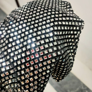 Détail macro du haut en maille sexy avec strass carrés scintillants sur tissu noir