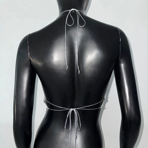 Detail of silver mesh halter top showing backless lace-up design on a mannequin