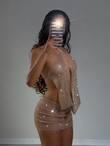 Détail du tissu en maille dorée champagne avec strass brillants sur la mini robe dos nu