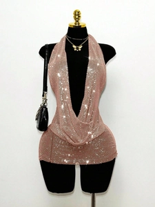 Détail de la mini-robe dos nu à paillettes or rose avec décolleté en V plongeant