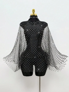 Dettaglio della mantella in rete nera con paillettes per outfit da festa e club