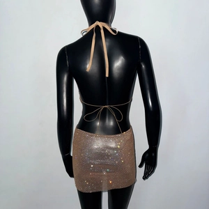 Détail du dos de la robe en résille dorée avec strass scintillants et dos nu sexy