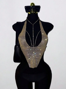 Detailed close-up of shiny gold rhinestone halter top with glittering metallic finish