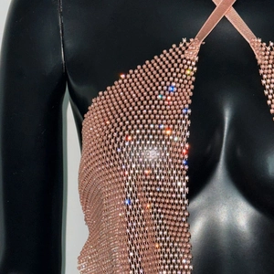 Gros plan sur les strass scintillants et la maille métallique or rose de cette robe dos nu