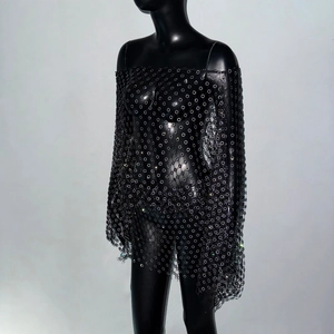 Dettaglio dell'abito in rete nera con spalle scoperte e decorazioni floreali in strass