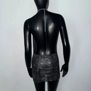 Dettaglio dell'abito a rete con strass con schiena scoperta e catene metalliche