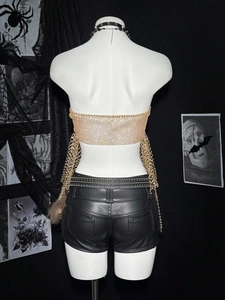 Detail view of rhinestone sequin crop top and studded leather shorts with chain belt