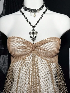 Macro detail of sheer mesh tube top with sparkling rhinestones and beaded fringe trim