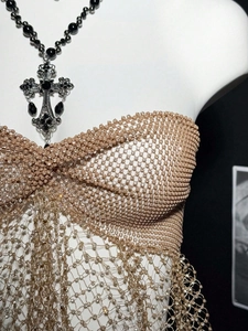 Macro view of champagne beaded mesh corset with rhinestone fringe and knot detail