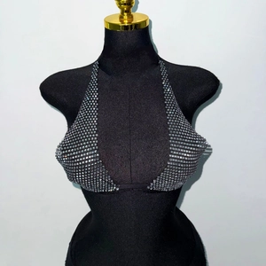 Detail of silver rhinestone halter top with glittering square crystals on black mannequin