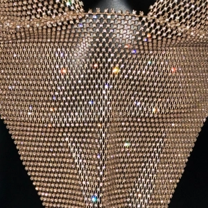 Close-up detail of sexy rhinestone fishnet halter top with rose gold metallic mesh texture