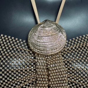 Gros plan sur un coquillage doré avec une maille de strass en cristal scintillants