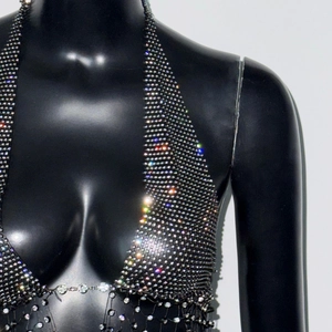 Détail du haut dos nu en maille noire avec strass argentés et structure de chaîne