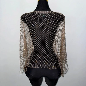 Close-up of sparkling rhinestone fishnet mesh shrug featuring long sleeves and openwork design