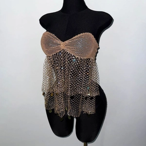 Detail of sexy fishnet top featuring sparkling rhinestones and gold sequin fringe
