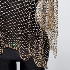 Detailed macro view of gold fishnet mesh with sparkling rhinestones for party wear