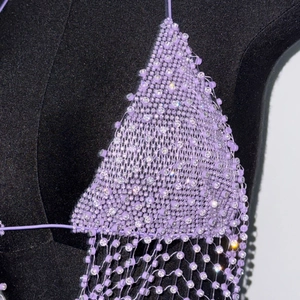 Detailopname van paarse mesh-top met strass-steentjes en glinsterende kralenfranjes