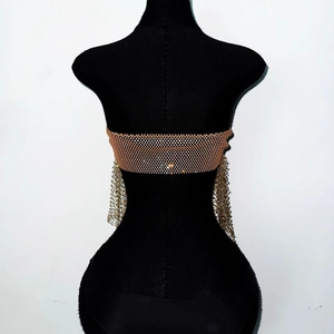 Detail of gold metal mesh top with rhinestones and long fringe tassels for party wear