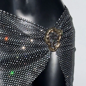 Detalle de minifalda de malla con diamantes de imitación y hebilla de metal dorada única