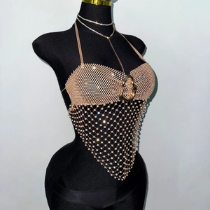 Détail du haut dos nu luxueux en résille de strass avec boucle dorée et collier assorti