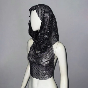 Detail view of the metallic chainmail hood and sequin mesh texture on the black crop top
