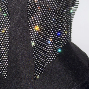 Gros plan sur les strass multicolores denses sur un tissu résille noir sexy