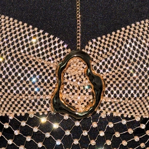 Détail de strass en cristal sur tissu résille avec chaîne dorée pour haut de fête