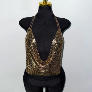 Détail du haut dos nu à paillettes métalliques avec motif léopard doré et chaînes