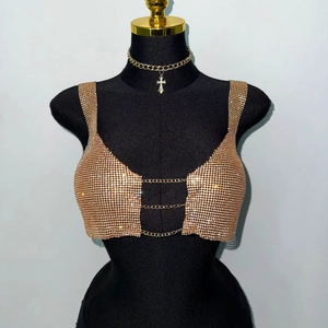 Detail view of champagne gold rhinestone cropped top with metal chain and cross necklace