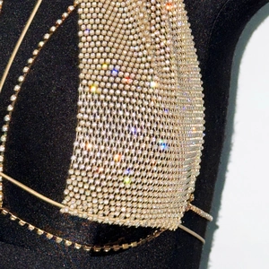 Nahaufnahme von luxuriösem champagnergoldenem Netzoberteil mit Strass auf Schneiderpuppe