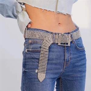 Ceinture en strass argentés avec boucle carrée portée sur un jean bleu pour un look chic