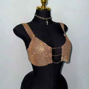 Detail of gold rhinestone mesh top with metal chain closures and matching cross necklace