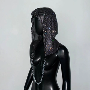 Détail de coiffe en résille noire avec strass brillants et grosse chaîne en métal argenté
