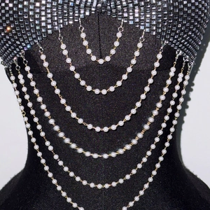Détail d'une chaîne de corps multicouche en perles avec strass brillants sur noir