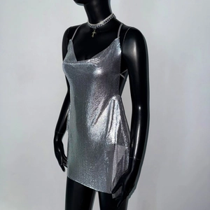 Detail shot of shimmering silver chainmail fabric and side draping on a party mini dress