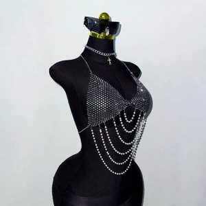 Détail du soutien-gorge chaîne en strass argenté avec cinq rangées de perles blanches et croix