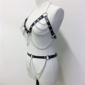 Detail view of black punk body harness with layered silver chains and metal rings