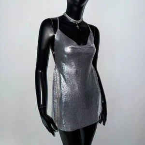 Detailed close-up of shiny silver metal sequin chainmail fabric on a sexy party mini dress