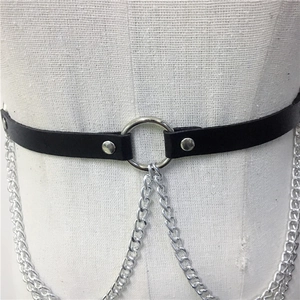Detail shot of punk style black leather body belt featuring silver metal rings and chains