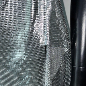 Close-up of silver metal sequin mesh fabric with reflective scale texture