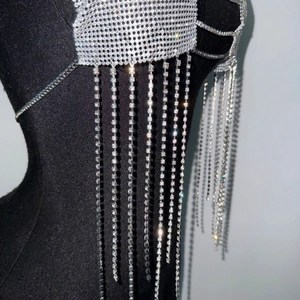 Détail de la chaîne de corps argentée avec strass scintillants et franges élégantes
