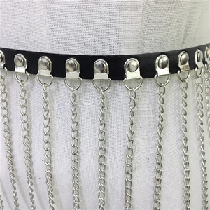 Detail of punk style black belt featuring silver metal fringes and rivet decorations