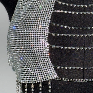 Gros plan détaillé d'un haut en maille de strass argentés avec chaînes de cristal