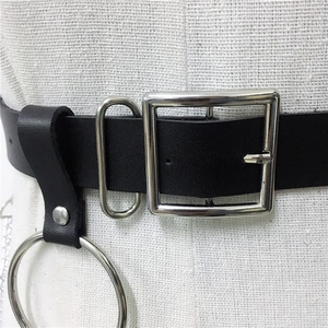 Macro detail of punk leather belt with silver square buckle and large metal ring