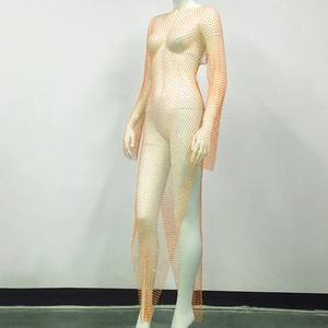 Detail view of orange rhinestone mesh dress showing intricate hollow-out net and side slit