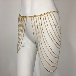 Détail d'une chaîne de corps multicouche dorée avec des pompons de strass brillants
