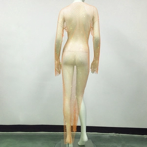 Détail d'une robe orange en maille à strass avec manches longues et tissu ajouré scintillant