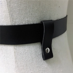 Detail of punk style black leather waist belt with silver metal ring and rivets