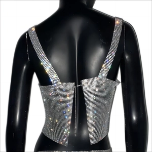 Close-up of silver sequin tank top with sparkling rhinestones and open back metal chains